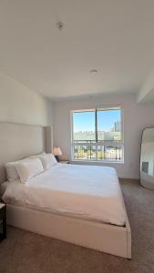 a white bedroom with a large bed and a window at Wallace Luxurious in Los Angeles +75 photos