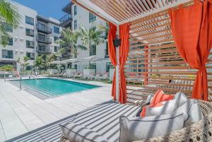 a swimming pool with an umbrella and a patio with at Wallace Luxurious in Los Angeles