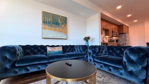 a living room with a blue couch and a table at Wallace Luxurious in Los Angeles