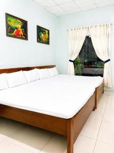 a large bed in a room with a window at Cali Homestay Tây Ninh in Tây Ninh +29 photos