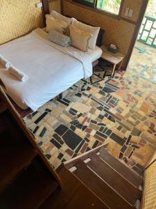 a bed in a room with a mosaic floor at Benny monkey house in Rayong