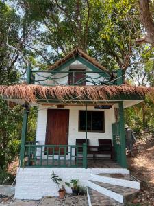 a small white house with a thatched roof at Benny monkey house in Rayong