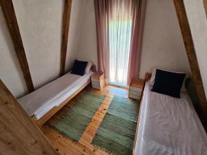 two beds in a room with a window at Koliba BUKOVICA in Šavnik