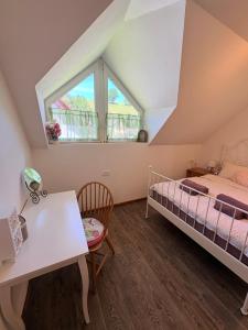a bedroom with a bed and a desk and a window at Apartma Arja in Spodnje Gorje