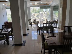 a restaurant with wooden tables and chairs and windows at Hill View Hotel in Astor