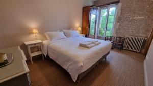a bedroom with a large bed with two towels on it at Domaine de Chaunac in Chaunac