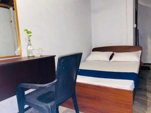 a bedroom with a desk and a chair next to a bed at Sea secret in Arugam Bay