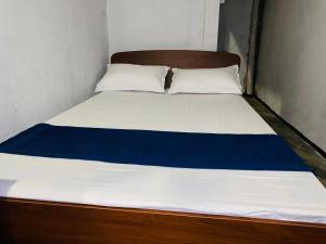 a bed in a small room with a blue and white mattress at Sea secret in Arugam Bay +3 photos