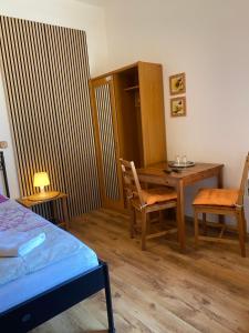 a bedroom with a desk and a table and chairs at Penzion Dukát in Vřesina