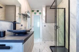 a bathroom with a sink and a glass shower at Prestige House in Nulvi +32 photos
