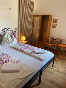 a bedroom with a bed and a table and a desk at Penzion Dukát in Vřesina