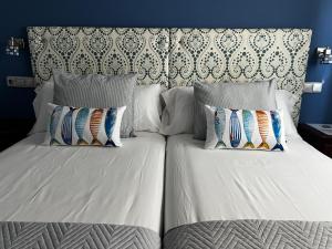 a bed with two pillows and a headboard at HOSTAL TREVELEZ in El Ejido