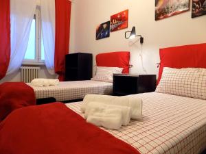 トリノにあるAppartamento Massauaの赤と白の部屋のベッド2台