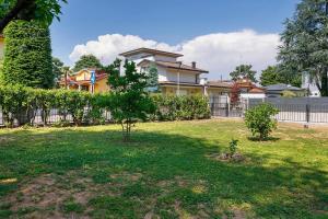 a house with a fence and a yard with trees at Villa Giusy in Verdellino