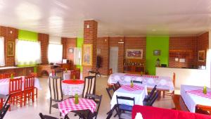 una sala da pranzo con tavoli, sedie e pareti verdi di Pousada Ponta da Pedra a Pedra Azul