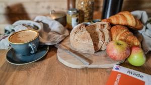 a table with a cup of coffee and a plate of bread and apples at Tin Bath As Glorious as its Namesake in Aller