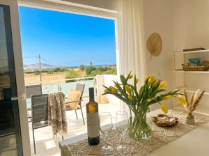 a table with a bottle of wine and wine glasses at Lilu Villa 2 with Private Pool and Seaview in Tigaki