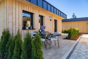 a patio with a table and chairs in front of a building at Ferienhaus Auerberg Sweet in Stötten am Auerberg