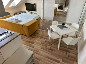 a small room with a bed and a table and chairs at Apartmány Skryjova in Brno