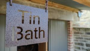 a sign hanging in front of a building at Tin Bath As Glorious as its Namesake in Aller