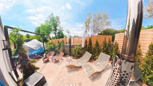 a patio with chairs and a fence with a tent at Garden Residence - The Garage in Drahobudice