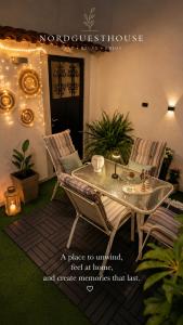 a patio with a table and chairs and a sign at Nord Guesthouse in Neos Pirgos