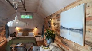 a bedroom with a bed and a brick wall at Tin Bath As Glorious as its Namesake in Aller +30 photos