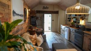 a living room with a couch and a kitchen at Tin Bath As Glorious as its Namesake in Aller