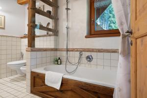 a bathroom with a tub and a toilet at Bnb Erba Maga in Rabbi +51 photos