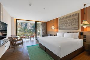 a bedroom with a large bed and a living room at Grand Mercure Krabi Ao Nang in Ao Nang Beach +70 photos