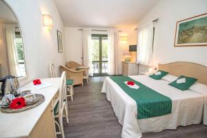 a hotel room with a bed and a table and chairs at Albaruja Hotel in Monte Nai