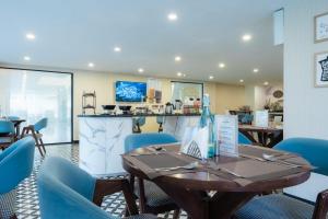 a dining room with a table and blue chairs at Hotel Limon Sector 45 Gurgaon in Gurgaon