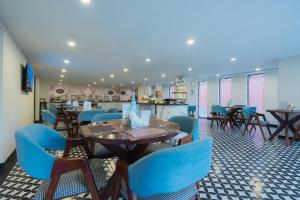 a restaurant with wooden tables and blue chairs at Hotel Limon Sector 45 Gurgaon in Gurgaon