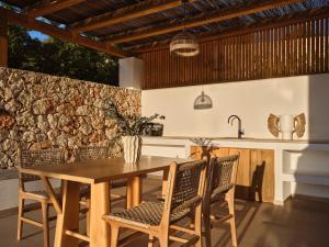 a kitchen and dining room with a wooden table and chairs at Theros Luxury Suites in Agios Nikolaos