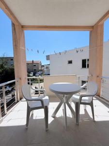 a table and two chairs and a table on a balcony at Guest House Koliqi - Hotel & Apartments in Ulcinj