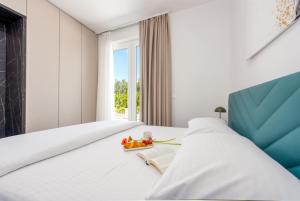 a bedroom with a large white bed and a blue chair at Villa Nika with pool & parking near Zadar in Bibinje +20 photos