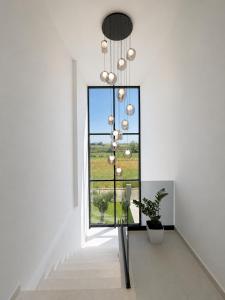 a white hallway with a window and a plant at Villa Azur in Draç