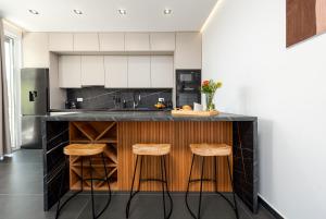 a kitchen with a black counter and stools at Villa Nika with pool & parking near Zadar in Bibinje