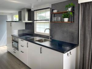 a kitchen with a sink and a counter top at Chalet Natuurrijk in Oisterwijk +37 photos