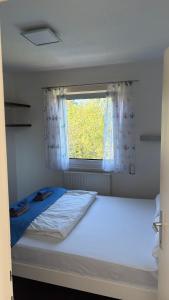 a small bedroom with a bed with a window at Haus am Waldrand in Göttschach