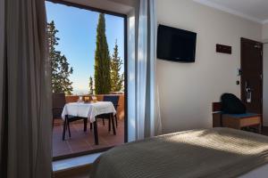 a room with a bed, table and window at Porcel Alixares in Granada