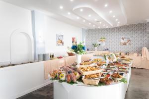 una linea di buffet con diversi tipi di pane e pasticcini di Resort Sciabache a Zambrone