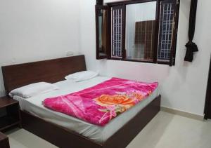 a bed with a pink blanket on it in a room at Tapovan ganga view in Uttarkāshi