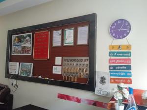 a bulletin board with a clock on a wall at Tapovan ganga view in Uttarkāshi