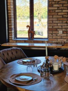 a wooden table with plates and dishes on it at B&B Landgoed de Bossenhoeve in Schayk