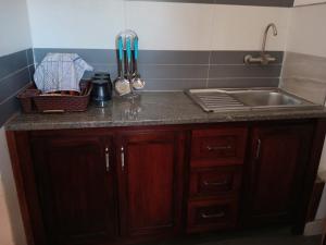 a kitchen with a sink and a counter top at Appart'hotel Les Capucins in Mahajanga +16 photos
