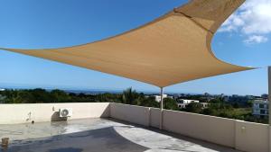 a large tan umbrella on top of a balcony at Sunset Haven in Flic-en-Flac