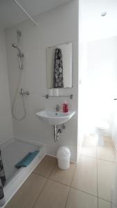 a white bathroom with a sink and a shower at Berl Inn in Berlin