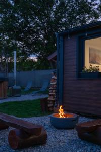 a fire pit in a yard next to a house at Tisza-tavi Kiserdő Lodge in Tiszaderzs