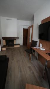 a room with a table and a flat screen tv at Berl Inn in Berlin